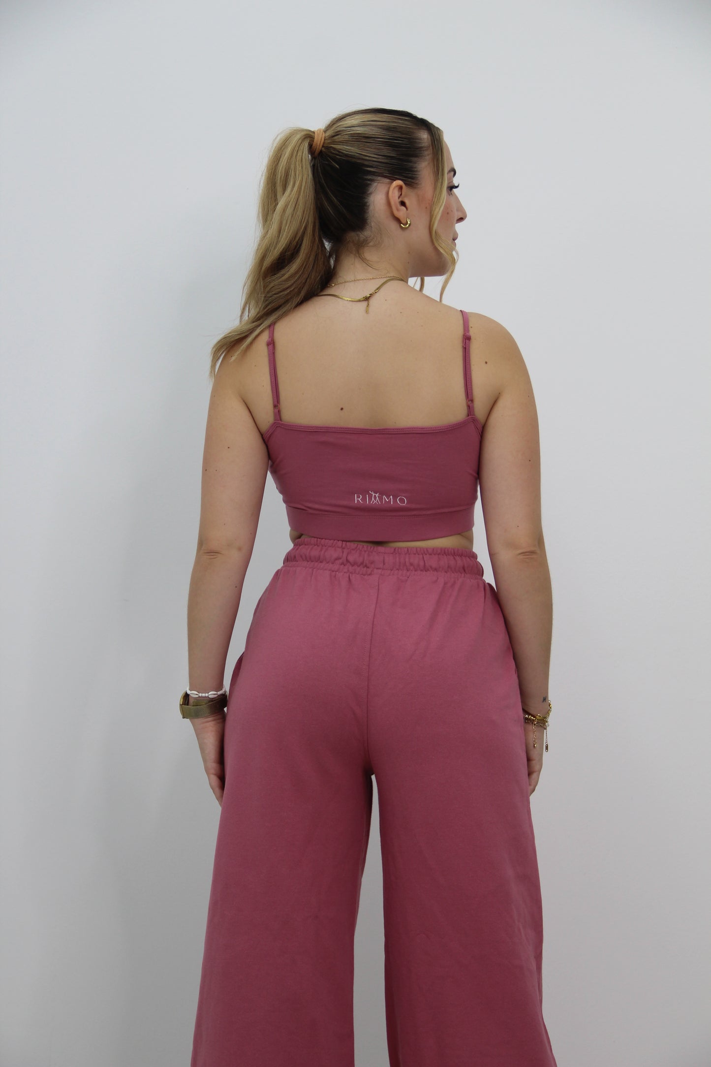 Vista trasera del conjunto urbano rosa de Rittmo, espalda al descubierto para libertad de movimiento en baile