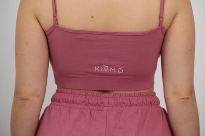 Parte trasera del conjunto urbano rosa de Rittmo con logo. Contraste de elegancia y frescura para bailar bachata con libertad y actitud