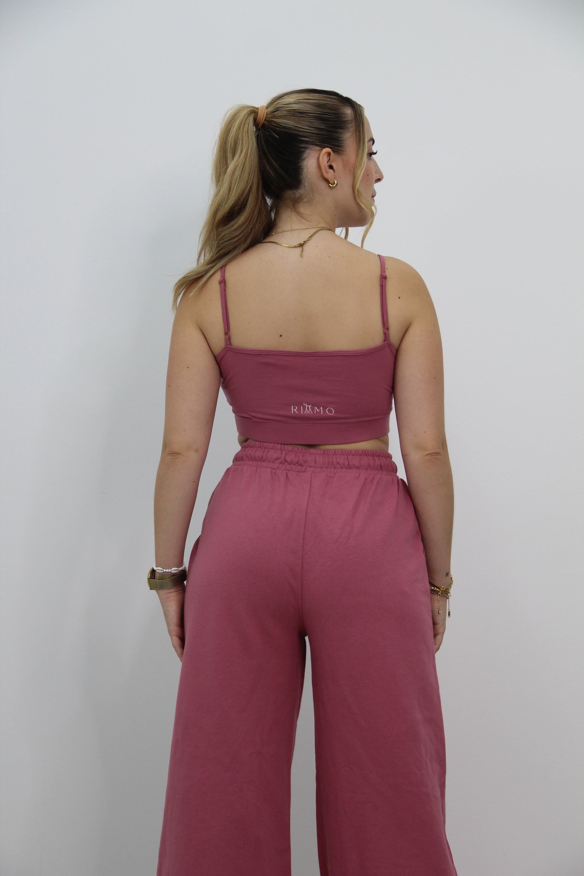 Vista trasera del conjunto urbano rosa de Rittmo, espalda al descubierto para libertad de movimiento en baile